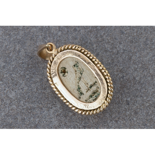 1374 - An 18ct gold and Egyptian scarab pendant, the grey stone scarab with traces of green enamel and carv... 