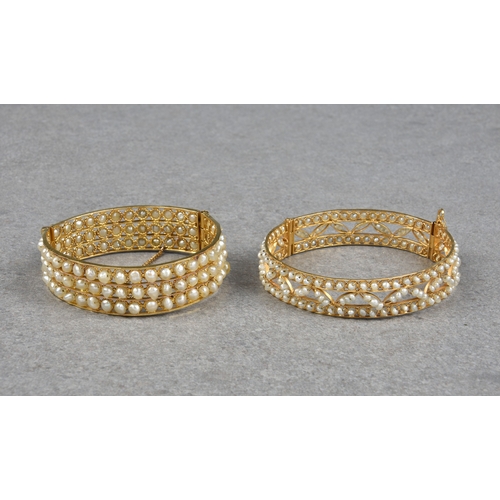 1025 - Two 22ct gold and pearl bangles, both hinged with sliding pin clasp, one set with three rows of appr... 