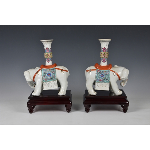 1664 - A pair of Chinese export porcelain famille rose elephant candle holders, 20th century, the two eleph... 