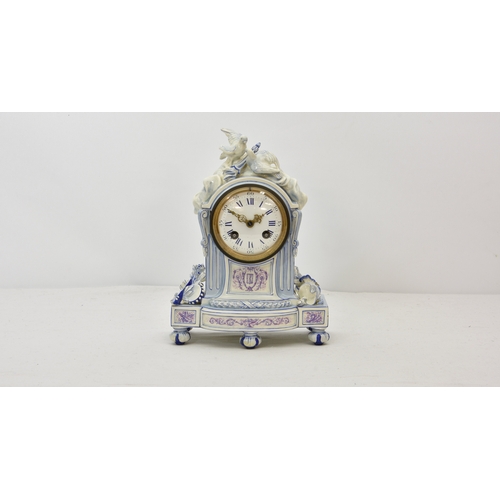 1941 - A French porcelain mantle clock, surmounted by two doves in white glaze, with lilac and blue decorat... 