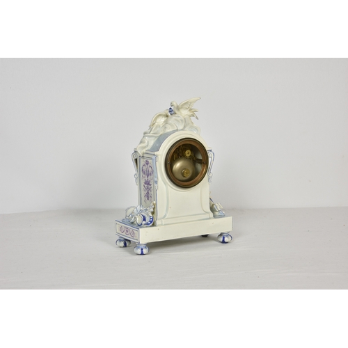 1941 - A French porcelain mantle clock, surmounted by two doves in white glaze, with lilac and blue decorat... 