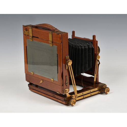 2085 - A Thornton Pickard mahogany cased field camera with tripod, brass fittings and lens, having ivorine ... 