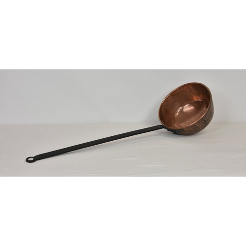 2135 - A large hammered copper and cast iron Black Butter ladle, overall length 36in. (91.4cm.) long, the b... 