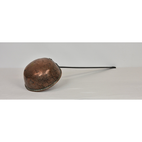 2135 - A large hammered copper and cast iron Black Butter ladle, overall length 36in. (91.4cm.) long, the b... 