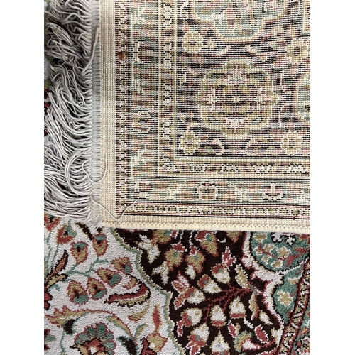 2177 - A heavy domestic Wilton wool rug on beige ground by Carmel Carpets of Israel, with floral medallion,... 