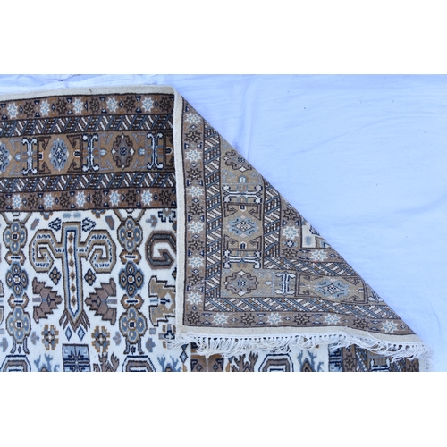 2179 - A Caucasian Kuba Peredil rug, on white ground with repeat rams horn and dagger motifs within a kufic... 