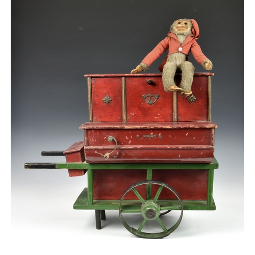 1267 - A 19th century or later painted wooden toy organ grinder music box, painted in red and green, the fa... 