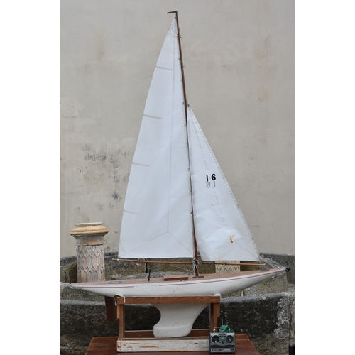 1268 - A large wooden pond yacht, having weighted keel, painted white hull with red trim, faux plank deck, ... 