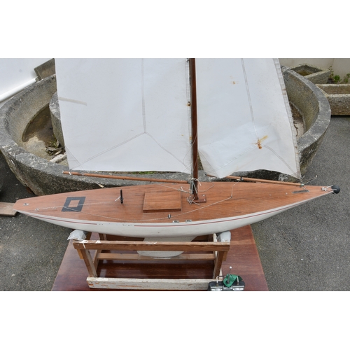 1268 - A large wooden pond yacht, having weighted keel, painted white hull with red trim, faux plank deck, ... 