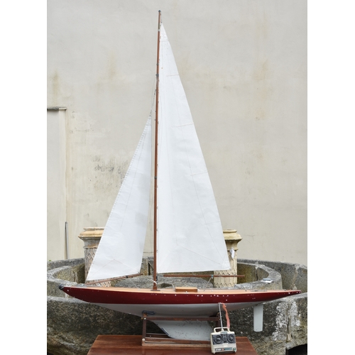 1269 - A large wooden pond yacht, having weighted keel, painted off white and burgundy hull, faux plank dec... 