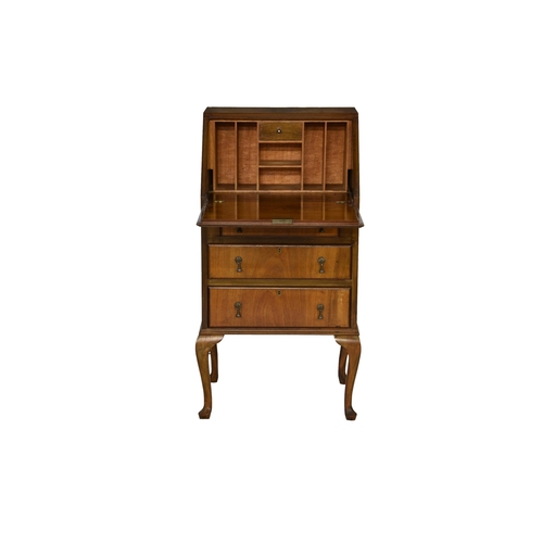 772 - A 1930's figured walnut bureau of small proportions, the fall front writing slope opening to a fitte... 