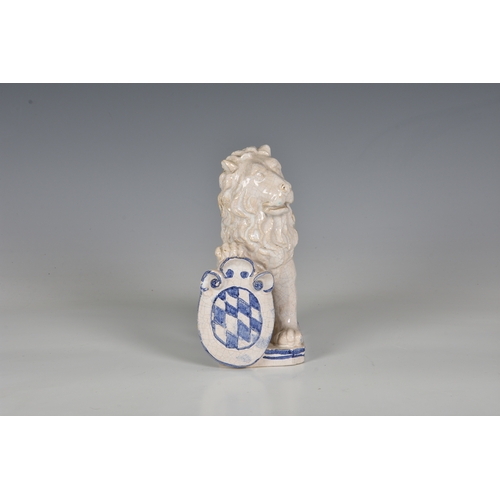 82 - A French faience figure of an armorial lion, probably early 20th century, the seated, white glazed l... 