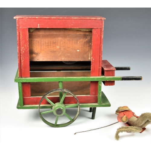 1267 - A 19th century or later painted wooden toy organ grinder music box, painted in red and green, the fa... 