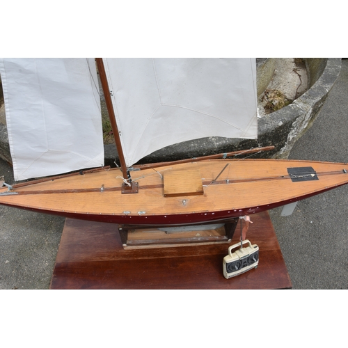 1269 - A large wooden pond yacht, having weighted keel, painted off white and burgundy hull, faux plank dec... 