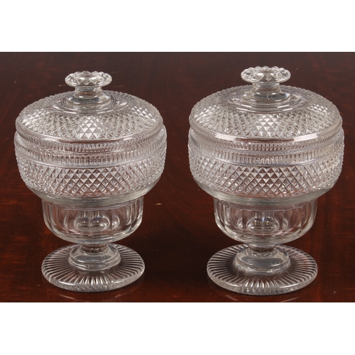 172 - A pair of Georgian cut glass urns and covers, the incuse lower section with facet cutting, the upper... 