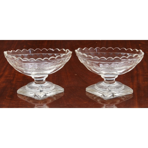 174 - A pair of Georgian cut glass navette pedestal dishes, on knopped stems and raised on round stepped b... 