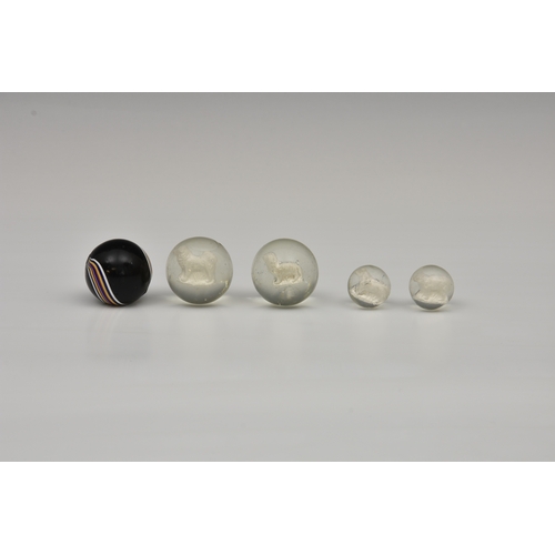 190 - Four rare sulphide glass marbles, two large containing different breads of dogs, 35mm and two smalle... 