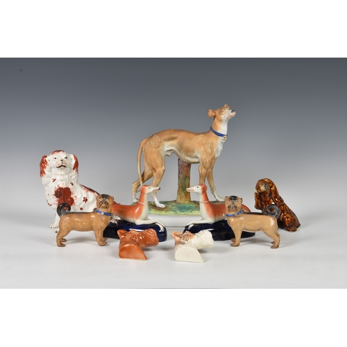 39 - A collection of antique / vintage ceramic dog models, to include two German porcelain pug dogs, earl... 