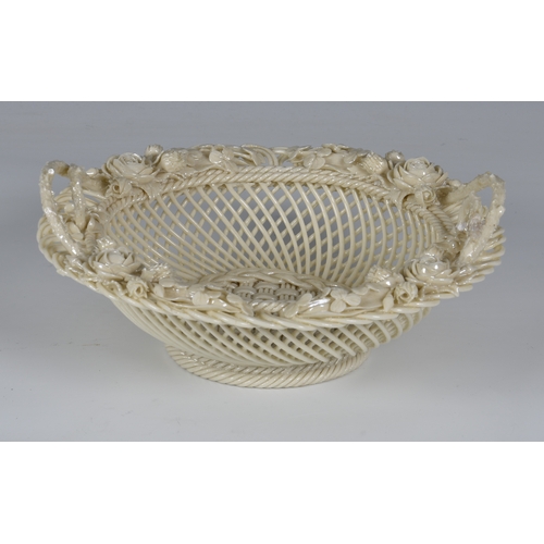 57 - An Irish Belleek pierced circular basket with iridescent glaze, twin double handles, clover leaves a... 