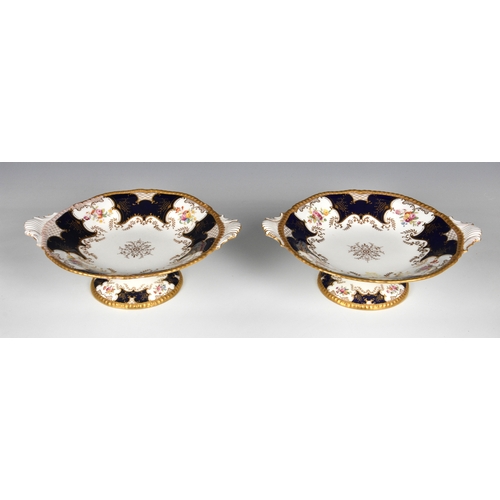 60 - A pair of English Coalport tazzas, of shaped circular form with twin moulded handles, royal blue and... 