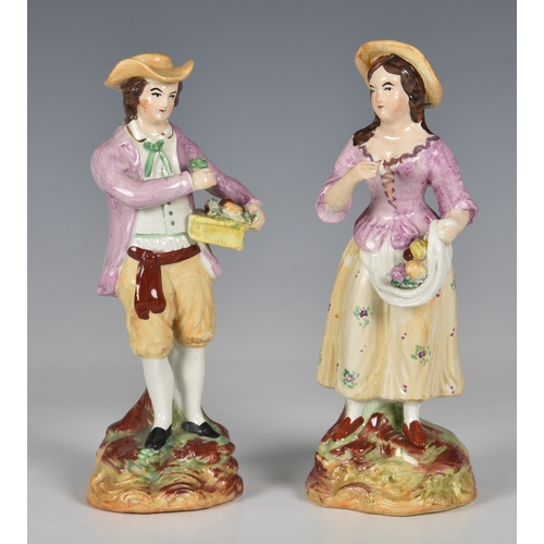 65 - A 19th century pair of Staffordshire figures, of a young man carrying a basket of fruit and young wo... 