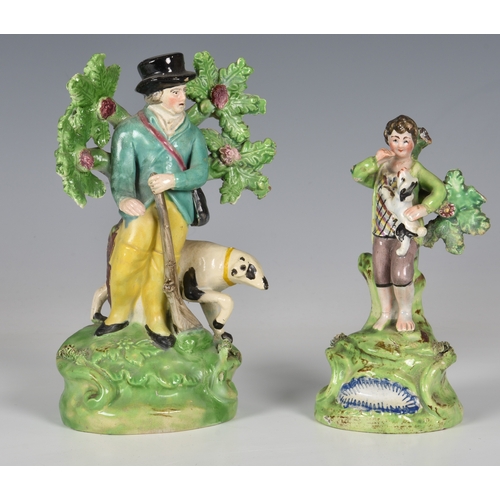 66 - A 19th century Walton Staffordshire figure of a boy playing with a puppy, which he is carrying in hi... 