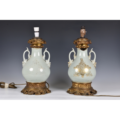 73 - A pair of 19th century porcelain vase lamps, probably French, the stout, baluster vases in a celadon... 