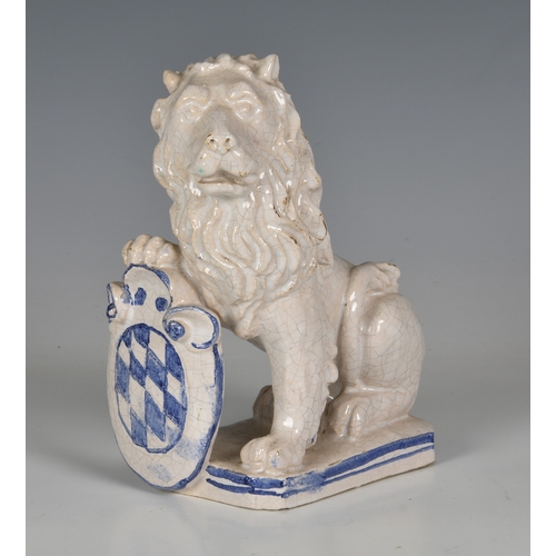 82 - A French faience figure of an armorial lion, probably early 20th century, the seated, white glazed l... 