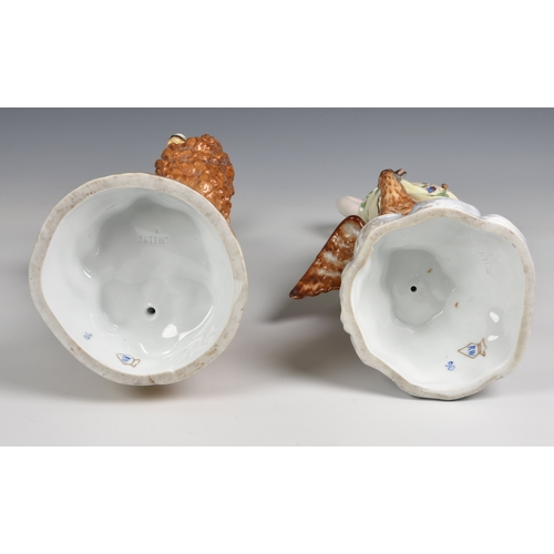 18 - A pair of Rudolstadt porcelain figures in floral dress  of Heracles standing with a lion and Hebe kn... 