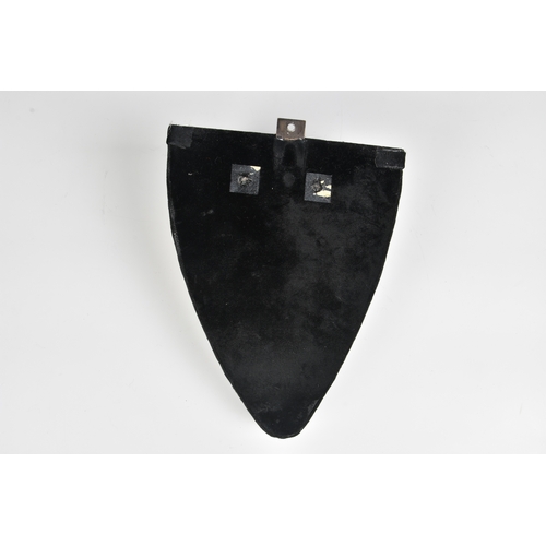 19 - A black velvet wall bracket  incorporating a glazed white porcelain figure of a young woman in a gro... 