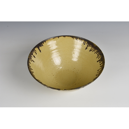 3 - A studio pottery bowl in the manner of Dame Lucie Rie  the flared, footed stoneware bowl in a mottle... 