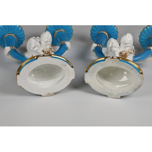 54 - A pair of Minton twin branch candelabras  of a central Cherub holding on each hand an outswept candl... 