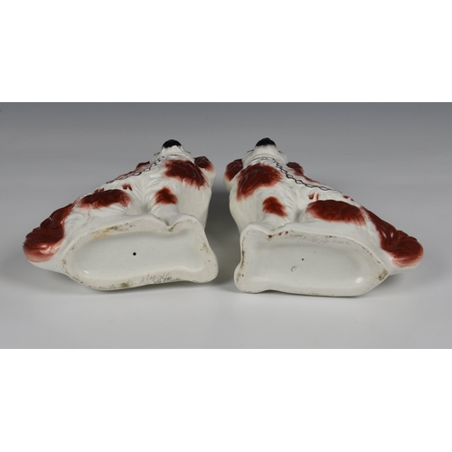 57 - A pair of Staffordshire King Charles spaniels  in brown white glaze with gilt collar and lead, unmar... 