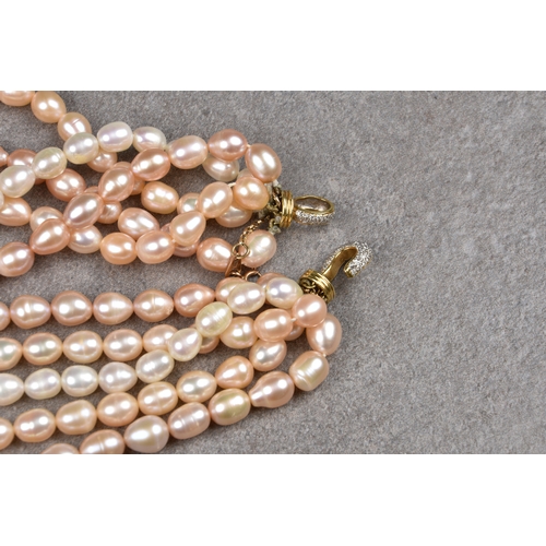 104 - A five strand freshwater pearl necklace the pink toned, oval pearls with diamond set hook and eye cl... 