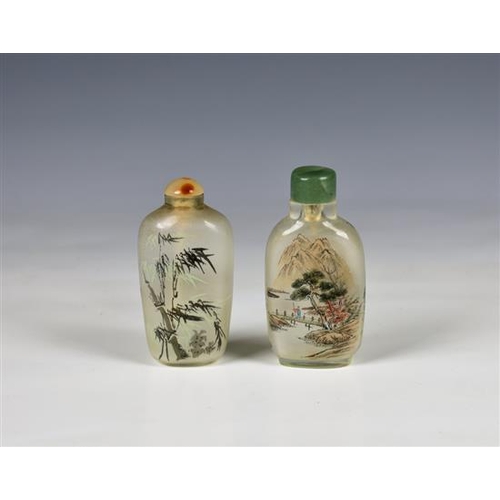 1179 - Two Chinese interior painted glass snuff bottles one painted with figures at a tree-lined lakeside a... 