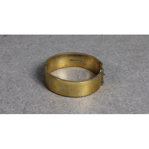 128 - A silver gilt bangle Smith & Pepper Ltd, Birmingham, 1934, push clip fastening, one half plain, the ... 