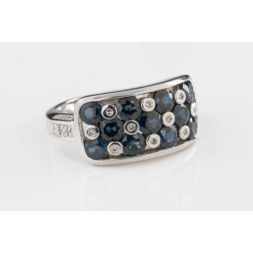 185 - A 9ct white gold sapphire and diamond ring the curved rectangular head set with eleven round cut sap... 