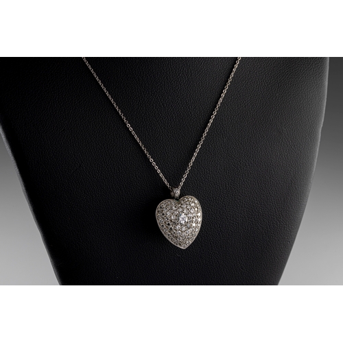 223 - A white and yellow gold diamond set heart shaped pendant the central round brilliant cut diamond app... 