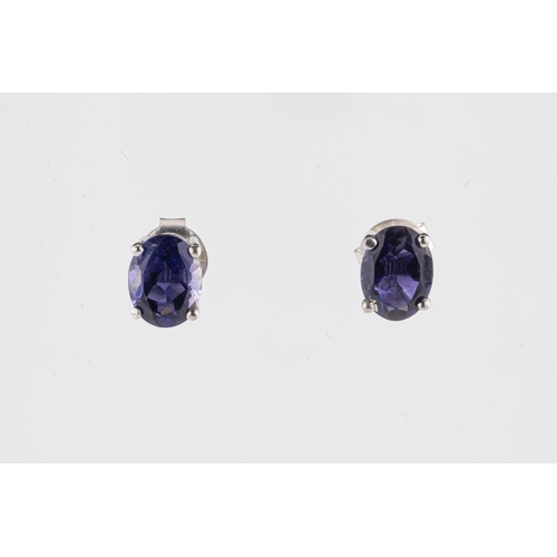 257 - A pair of silver iolite stud earrings the oval cut stones in four prong settings, post and butterfly... 