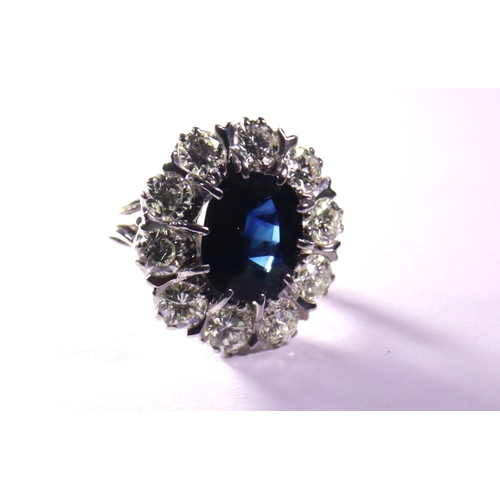 310 - A diamond and sapphire dress ring the central sapphire 5.5ct. approx surrounded by diamonds of 2.5ct... 