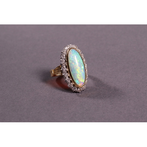 319 - An oblong opal and diamond dress ring set in 18ct. yellow gold.