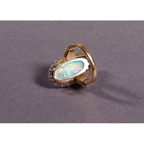 319 - An oblong opal and diamond dress ring set in 18ct. yellow gold.