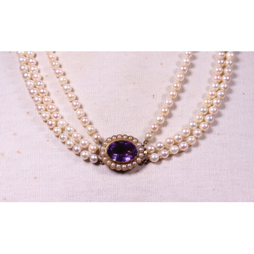 323 - A 3 row cultured pearl necklace with amethyst and pearl clasp in 9ct. gold.