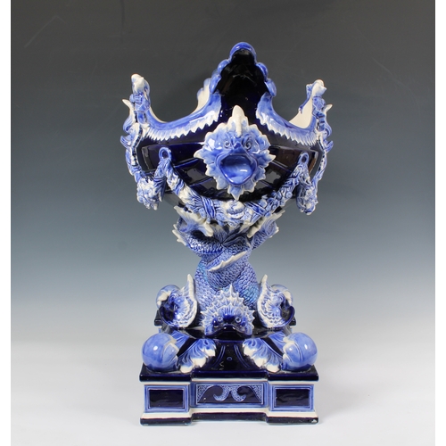 384 - An impressive ceramic blue glazed jardiniere of navette form, having dolphin head lugs and supported... 