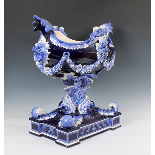 384 - An impressive ceramic blue glazed jardiniere of navette form, having dolphin head lugs and supported... 