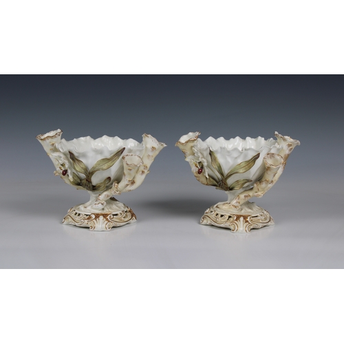 392 - Pair of Moore Bros. porcelain centerpiece bowls of organic form with a pinched rim, flanked by three... 