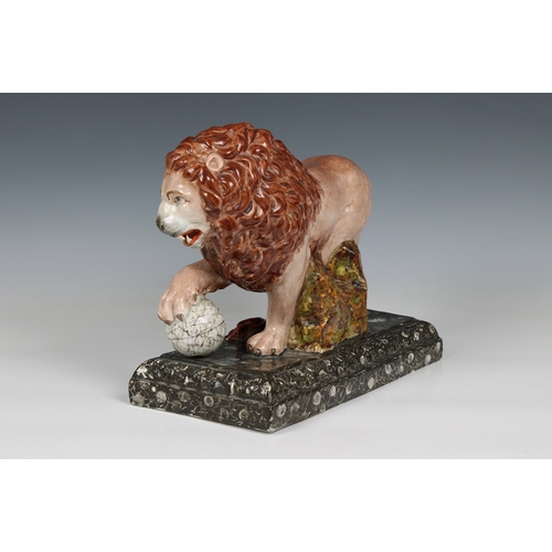 401 - An early 19th century Staffordshire pottery figure of a lion with a paw on a globe, modelled on one ... 