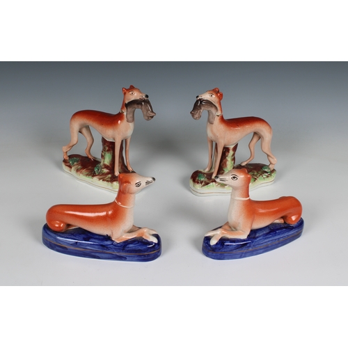 405 - Two pairs of Staffordshire pottery greyhounds two with rabbits in their mouths, 5½in. (14cm.) high &... 