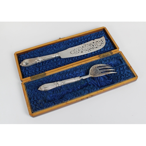 474 - A Victorian silver serving knife and fork with pierced and engraved scrolling decoration in a fitted... 