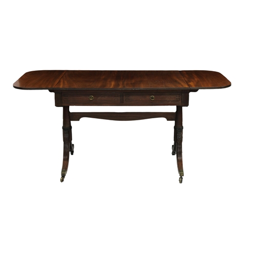 781 - A Regency mahogany sofa table with two drawers with brass handles and ebony stringing, and a shaped ... 